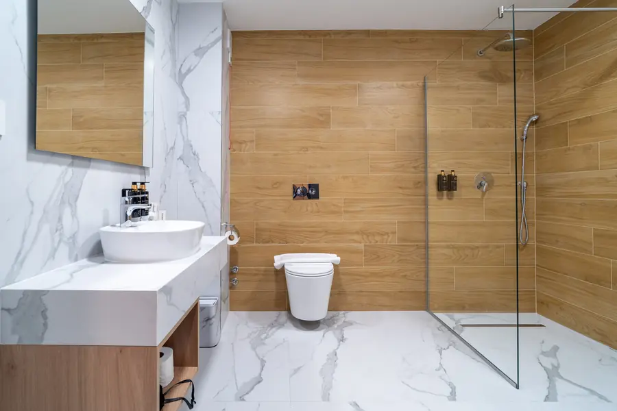 Baño con ducha a ras de suelo y revestimiento de madera