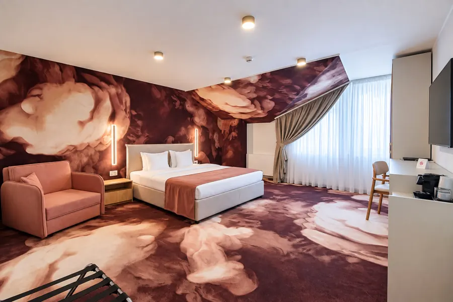 Dormitorio con decoración de nubes granate y sillón rosa