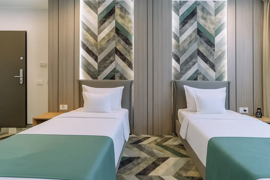 Dos camas twin, simétricas, bajo la pared de espiga