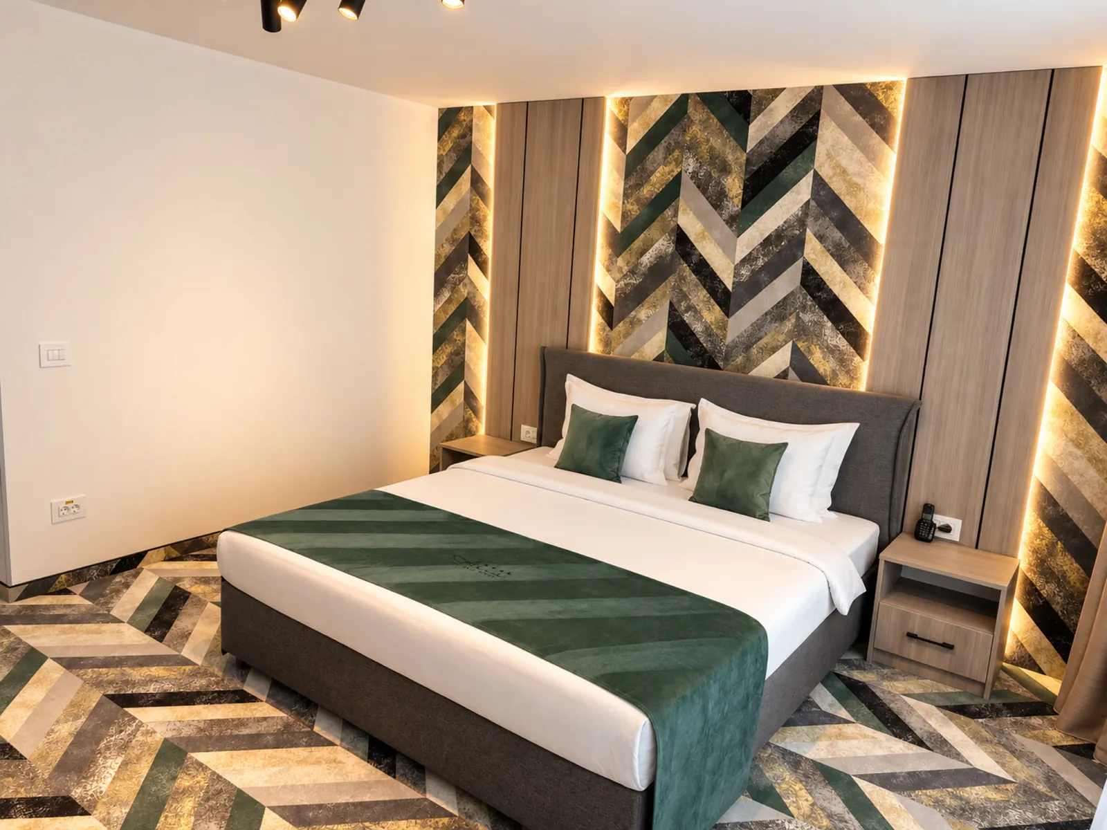 Camera da letto con parete chevron verde e luci calde