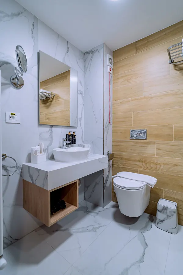 Baño con ducha y lavabo sobre encimera de mármol