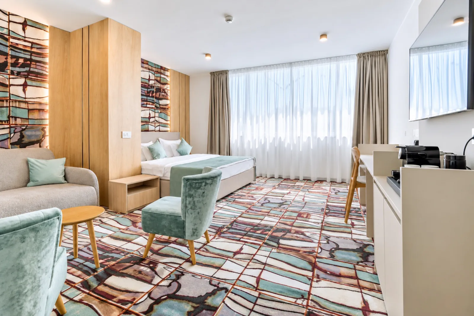 Family Suite con zona de estar y sillones de terciopelo verde