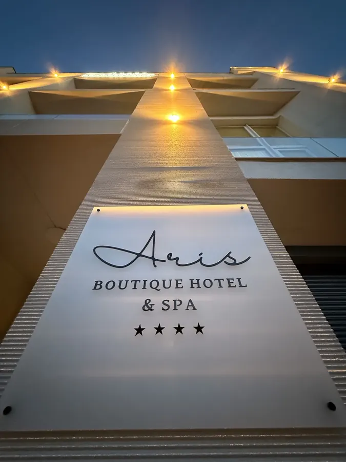 El letrero de Aris Boutique Hotel & SPA, iluminado por la noche