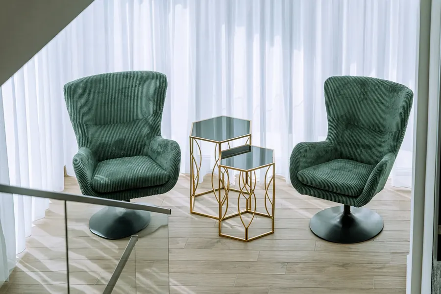 Sillones de terciopelo verde y mesas doradas, a la luz del día