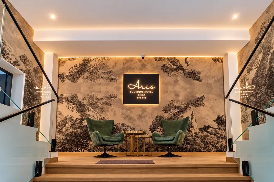 El vestíbulo del hotel, con el logotipo de Aris iluminado y sillones verdes