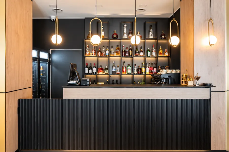 El bar, con estanterías de botellas iluminadas