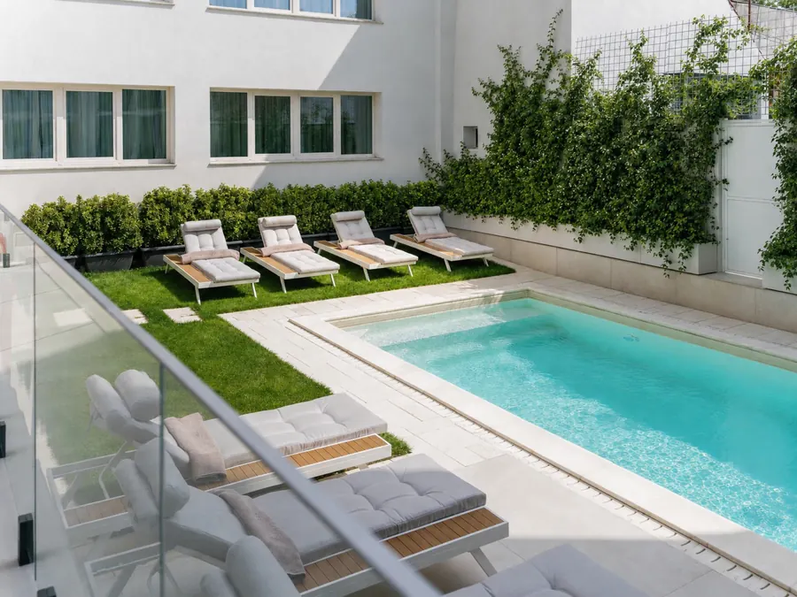 Der Außenpool mit Sonnenliegen im Innenhof des Hotels